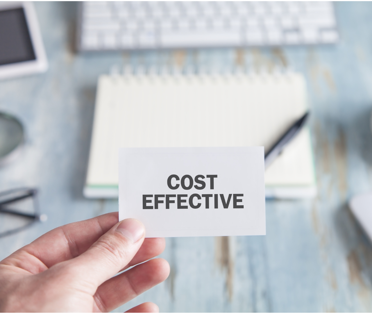 Hand holding a card with "Cost Effective" written on it, symbolizing the importance of budget-friendly SEO outsourcing services that offer a wide range of solutions with clear, detailed contracts and competitive pricing.