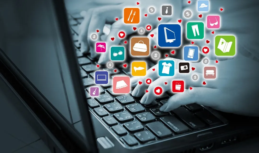 Hands typing on a laptop keyboard with colorful icons representing various services and products, symbolizing the enhancement of online presence through targeted SEO and content marketing strategies for a cosmetic dentistry practice.