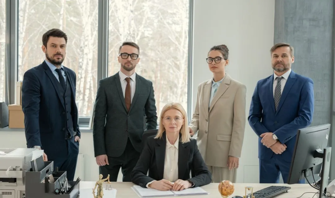 Group of corporate lawyers posing confidently in an office, representing a corporate law firm's successful SEO strategy that improved online presence, increased organic search traffic, and attracted high-profile clients through targeted keywords and content marketing.