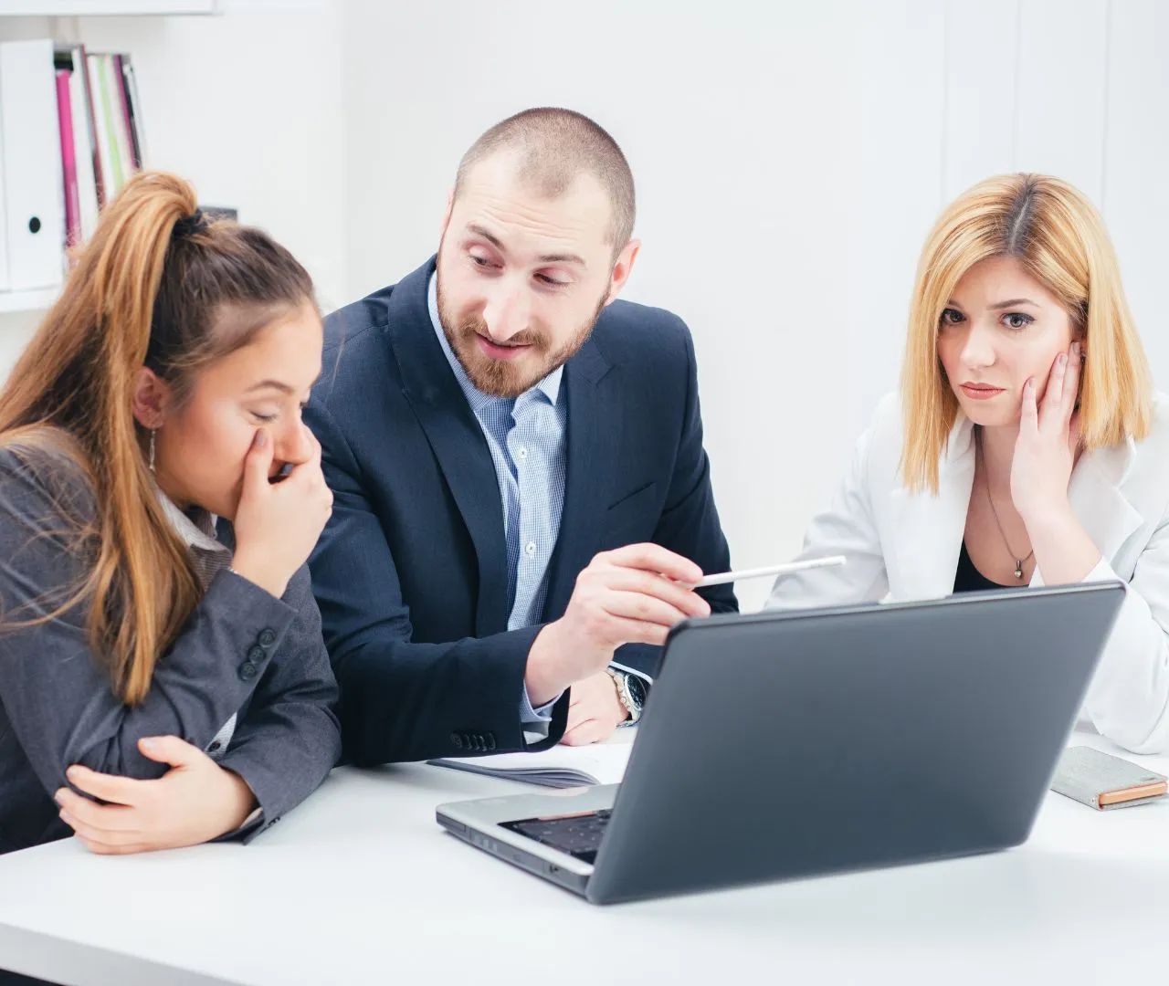 A team of professionals discussing SEO performance in front of a laptop, emphasizing ongoing support and regular monitoring to ensure the success of SEO strategies for dental practices.