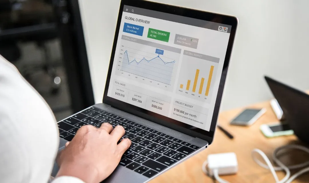 A person analyzing SEO performance data on a laptop, showing graphs and charts related to traffic and sales, representing the successful implementation of an SEO strategy that doubled organic traffic and lead generation for a real estate agency in Miami.